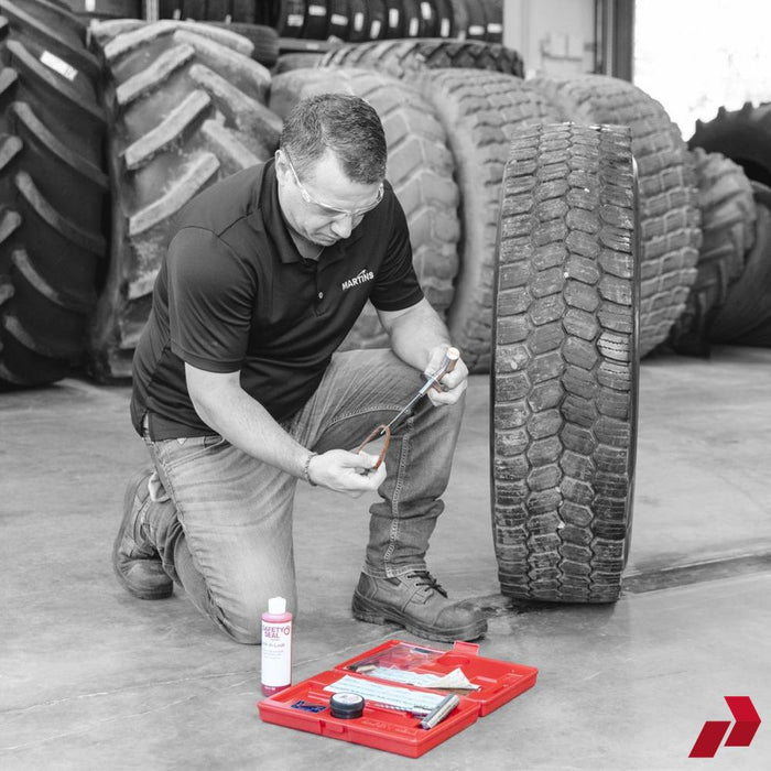 Technician using Safety Seal Deluxe Truck Kit to repair a large truck tyre
