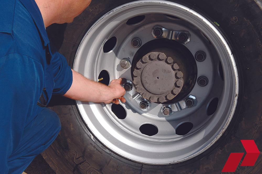 Prolock Wheel Nut security clamps attached to a wheel, with a man testing it with his fingers