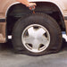 Flat tyre on a vehicle before repair