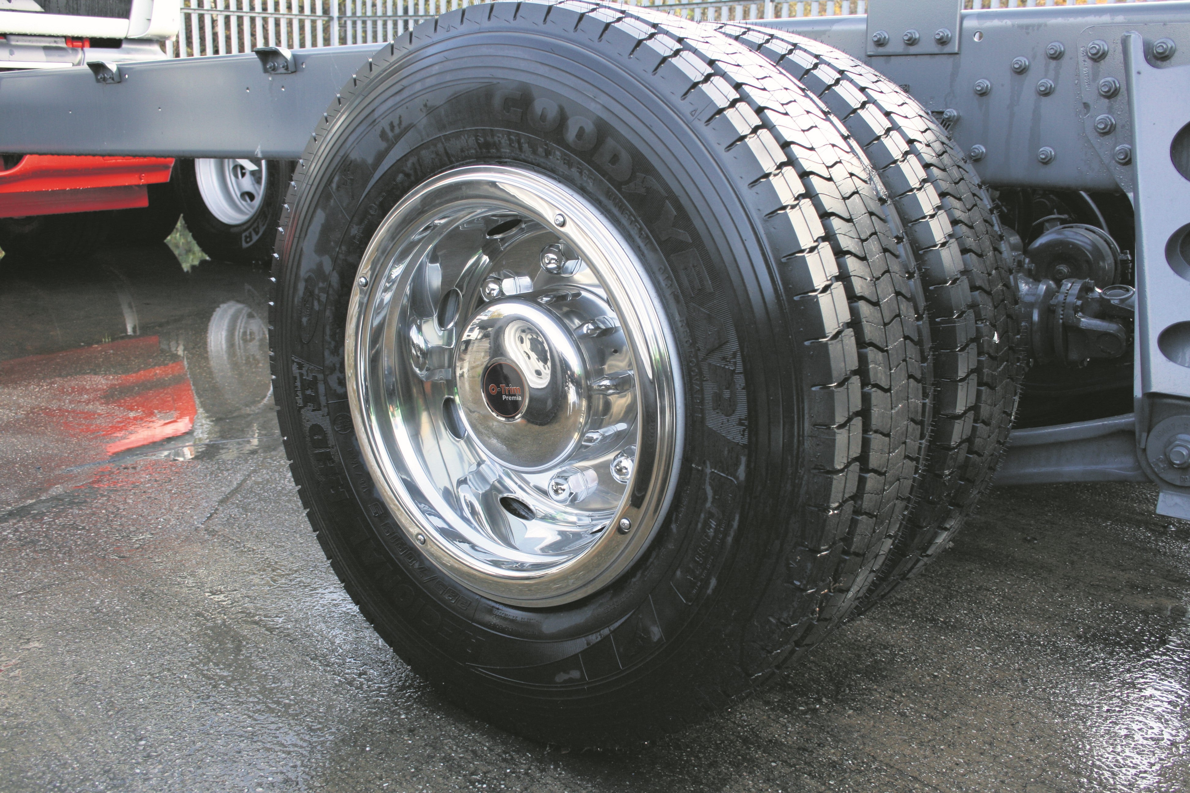 a large lorry wheel outside with a shiny, mirror-like wheel trim, freshly applied.
