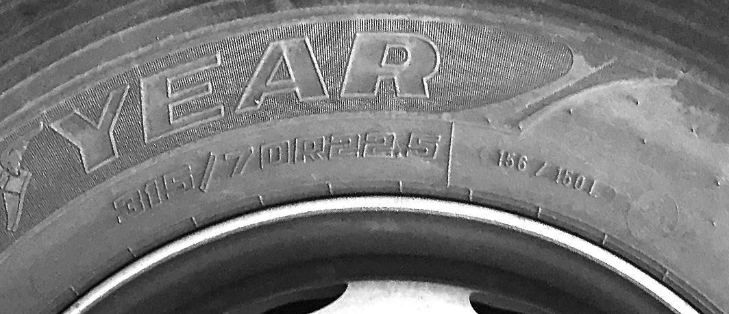 A photo of a close up of an HGV tyre. It shows the letters and numbers embossed into the tyre.