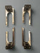 Four metallic brackets on a gray background
